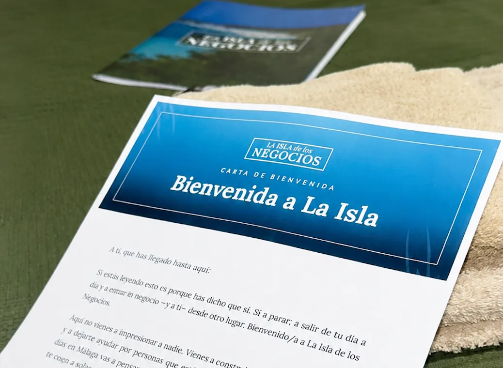 La carta de bienvenida de La Isla de los Negocios sobre la cama de una habitación